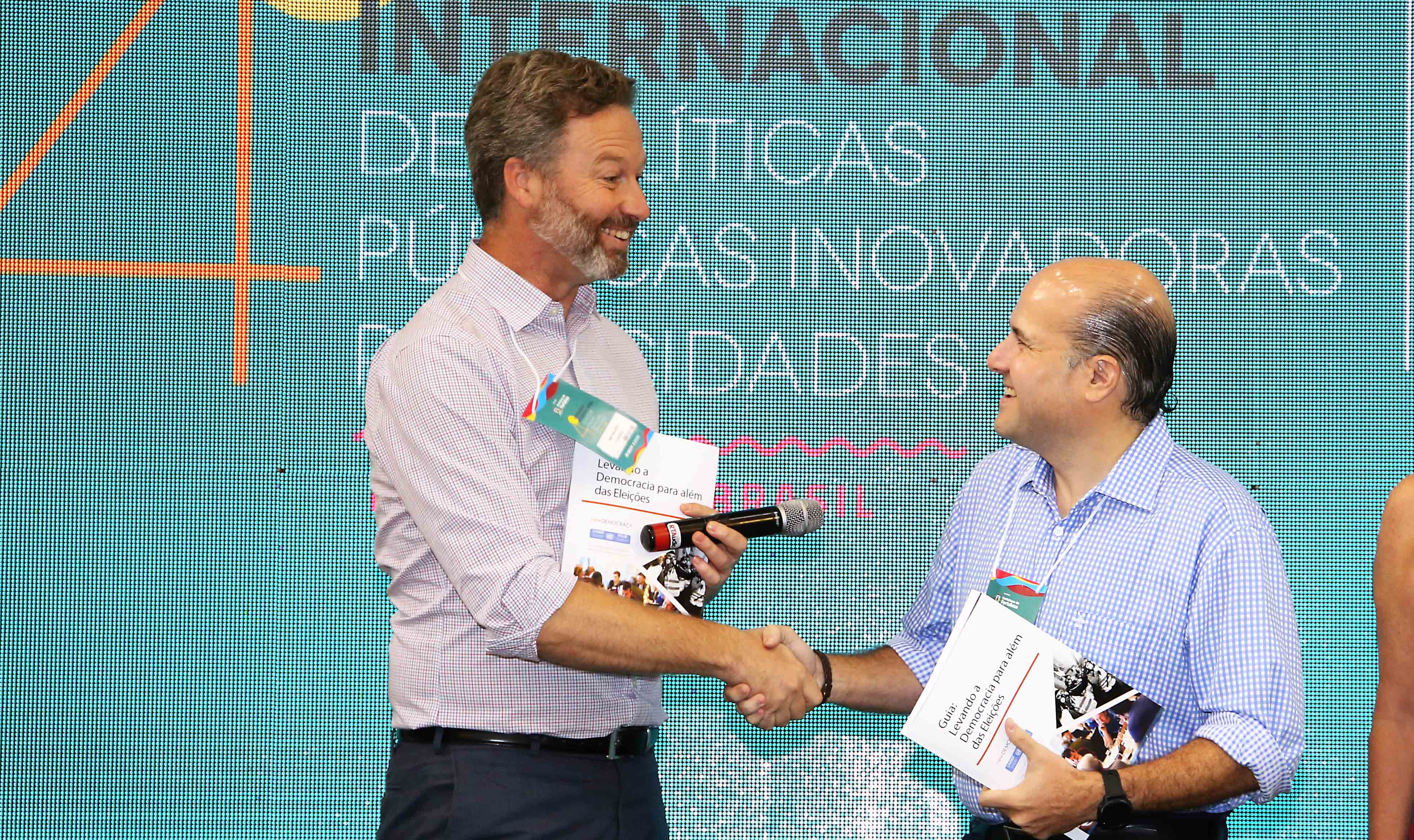 homem e prefeito apertando as mãos e sorrindo um para o outro